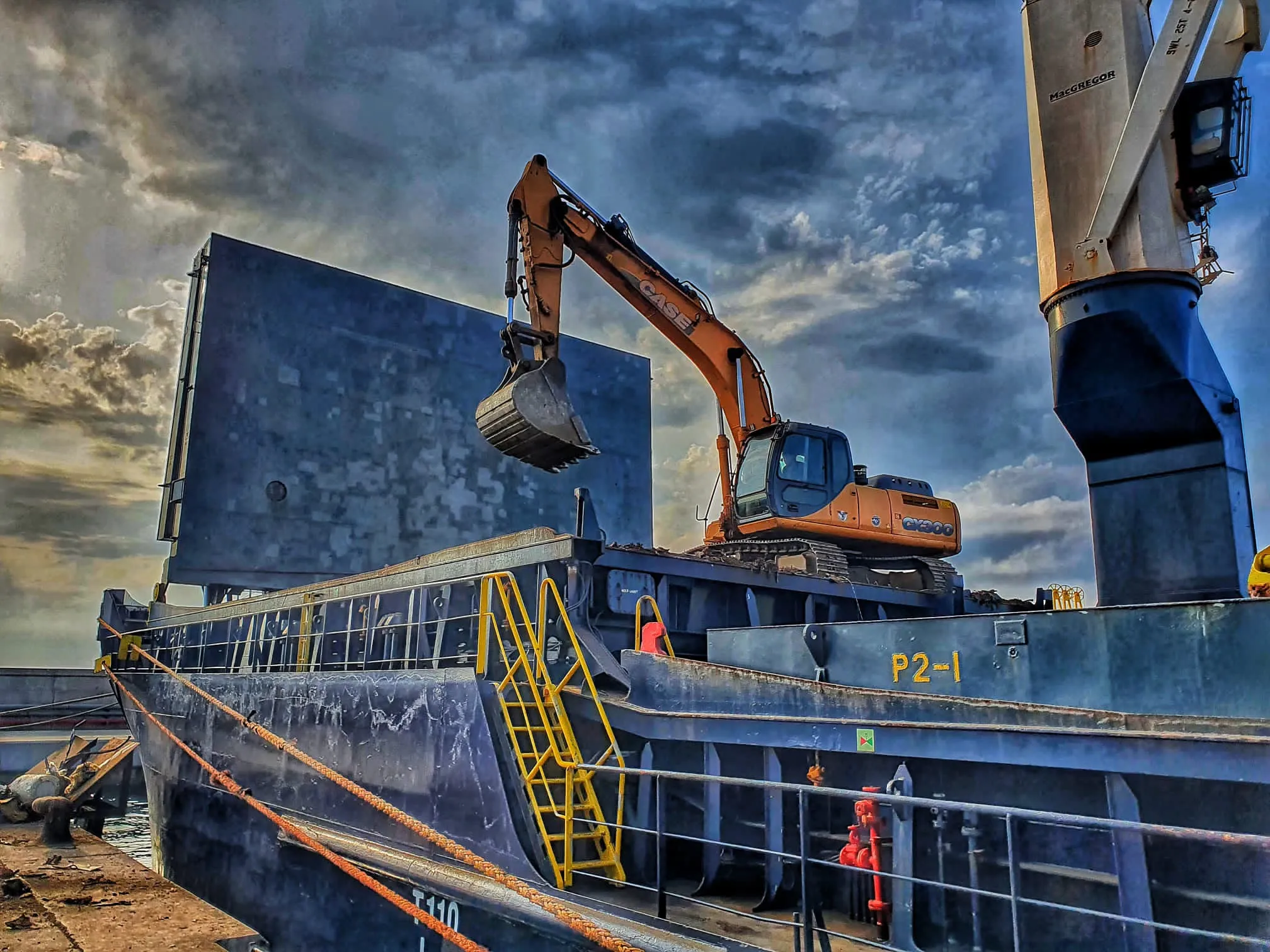 Excavadora cargando material en una operación portuaria