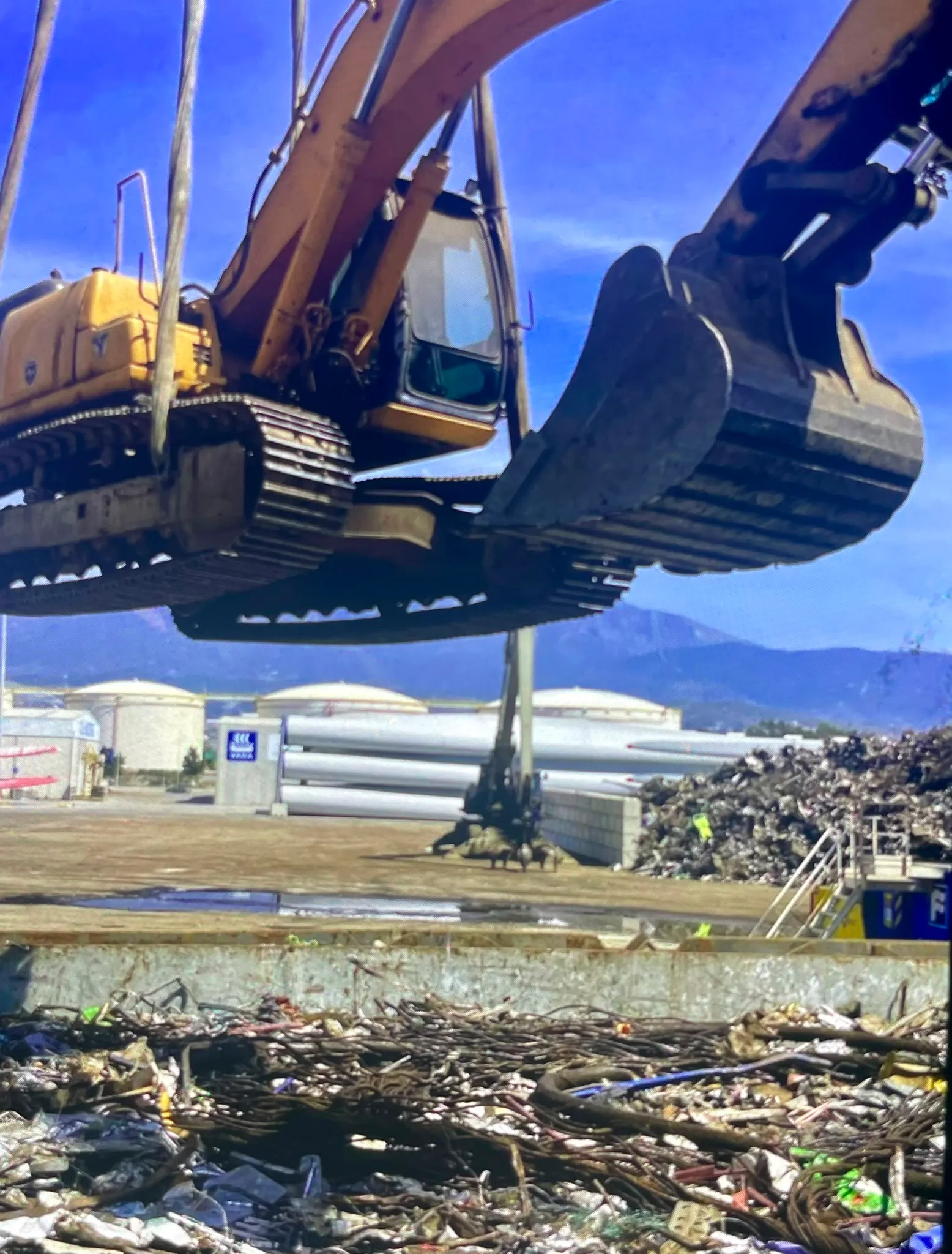 Maquinaria trabajando junto a materiales metálicos en una zona portuaria